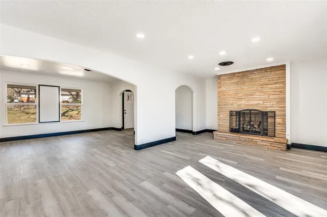 a view of a livingroom with wooden floor and a fireplace