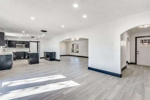 a living room with stainless steel appliances kitchen island furniture and a wooden floor