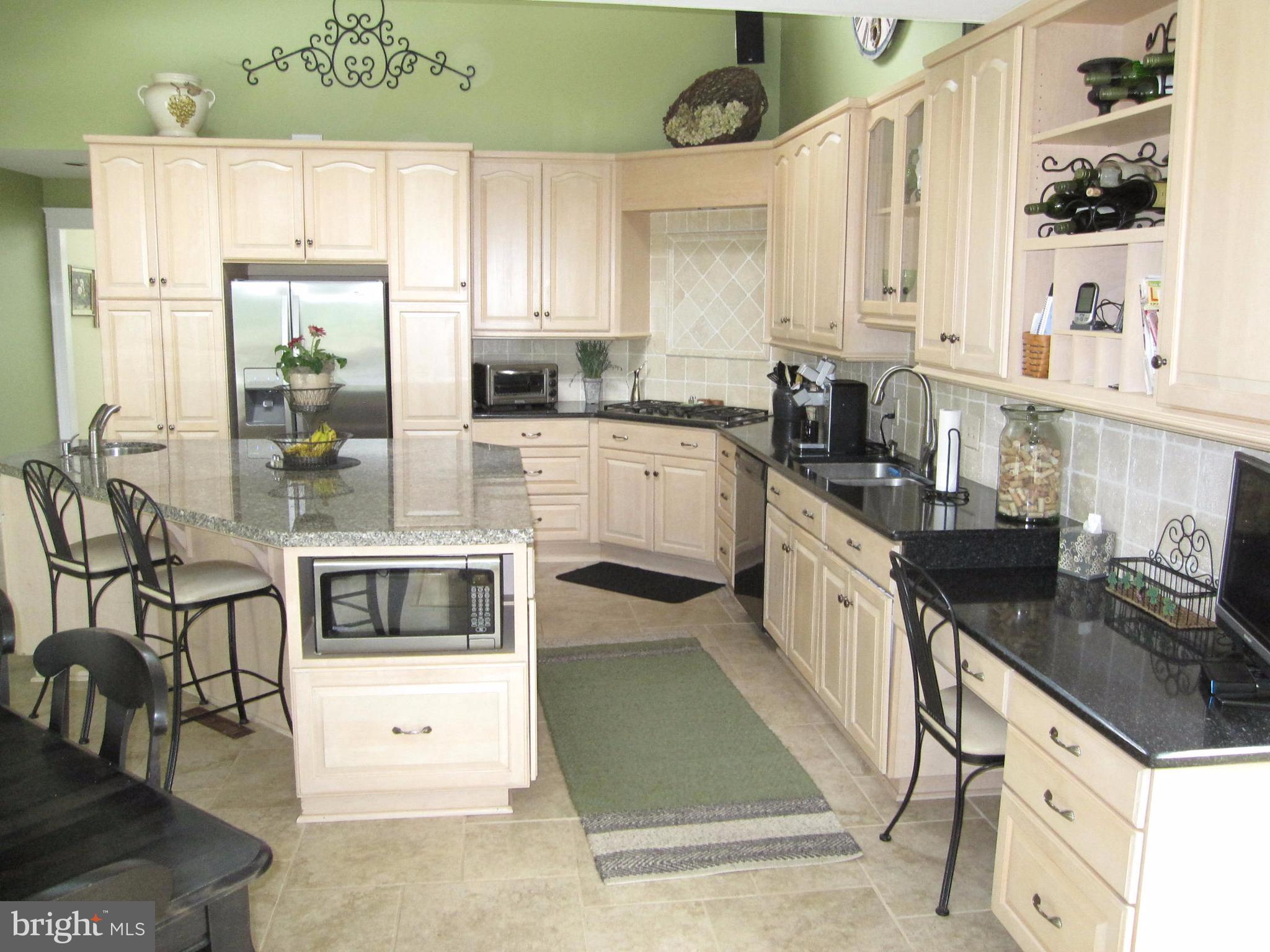 906 Huntsman Road Baltimore, MD 21286 - Photo 15 of 30 a kitchen with granite countertop a stove a sink and a microwave