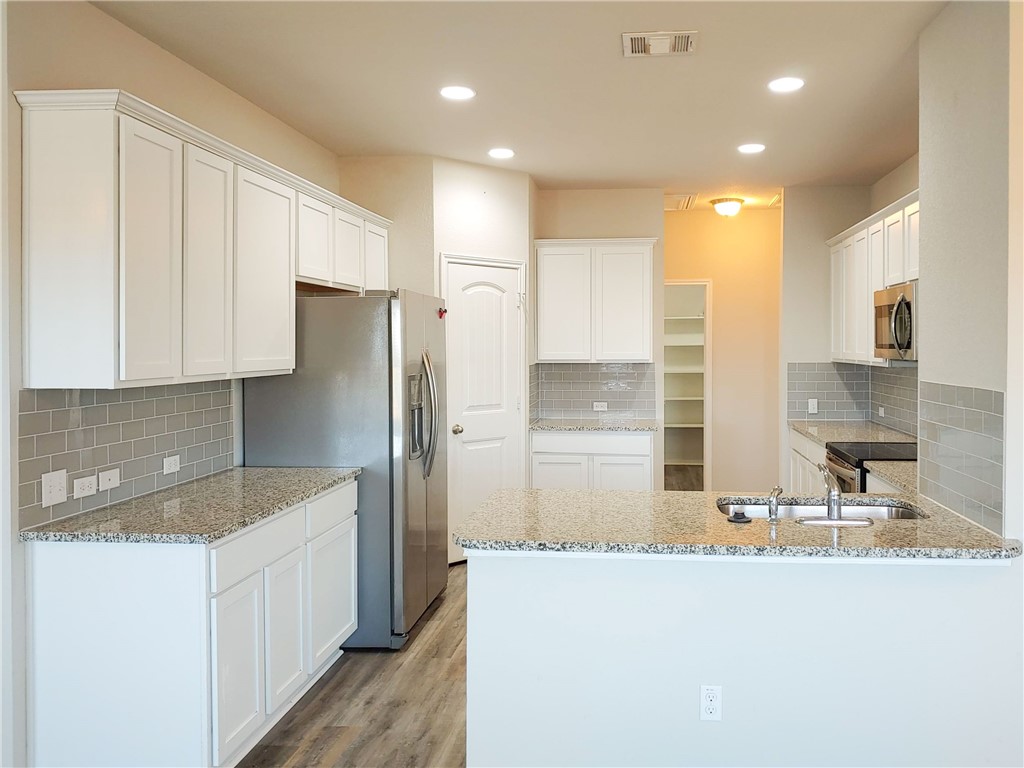 636 Donegal Lane Georgetown, TX 78626 - Photo 3 of 15 a kitchen with stainless steel appliances granite countertop a sink and a refrigerator