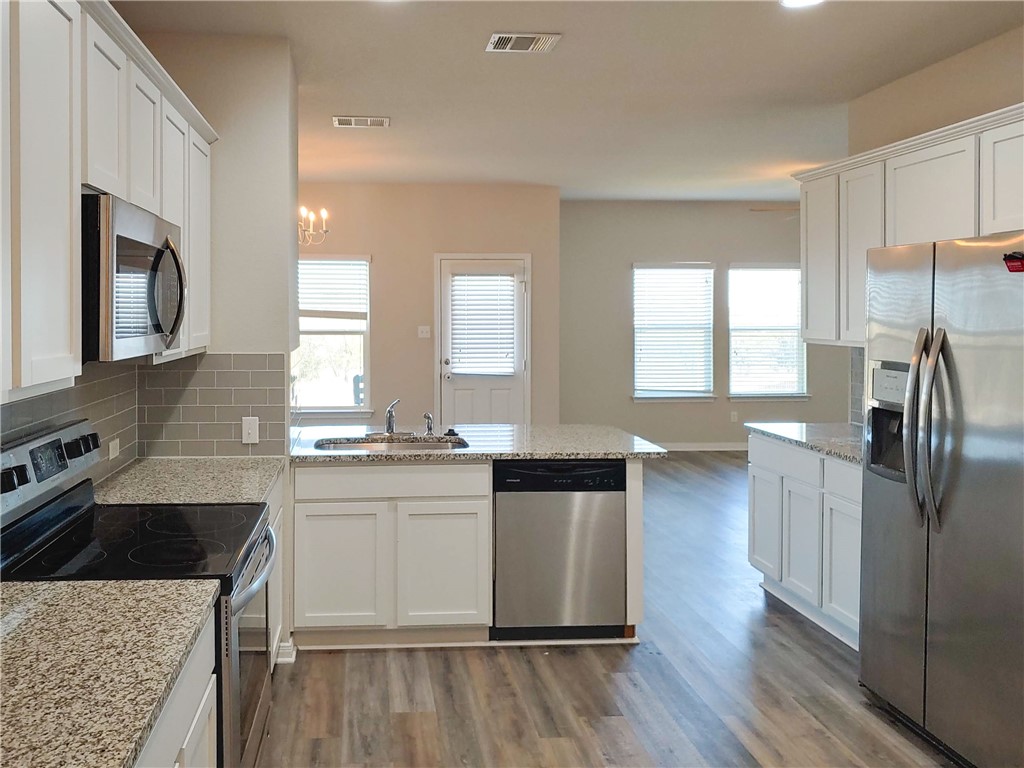 636 Donegal Lane Georgetown, TX 78626 - Photo 4 of 15 a kitchen with granite countertop a sink stove and refrigerator