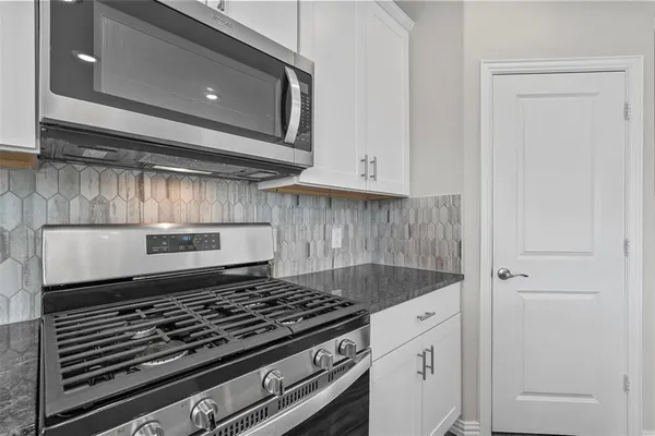 a kitchen with white cabinets and white appliances