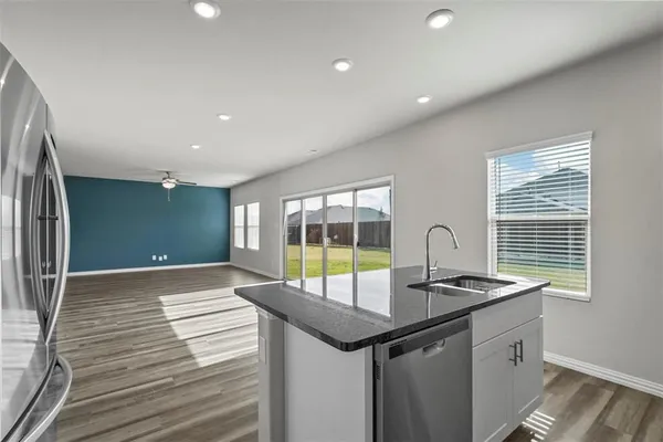a kitchen with stainless steel appliances granite countertop a sink and a stove