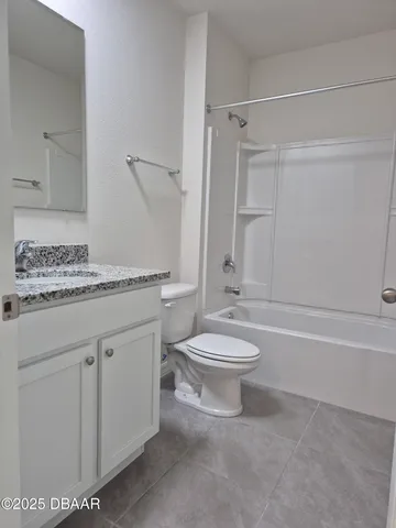 a bathroom with a granite countertop toilet a sink and a bathtub