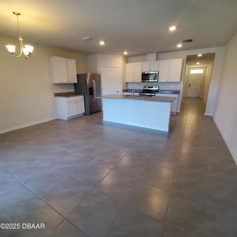 a kitchen with stainless steel appliances granite countertop a refrigerator and a stove top oven