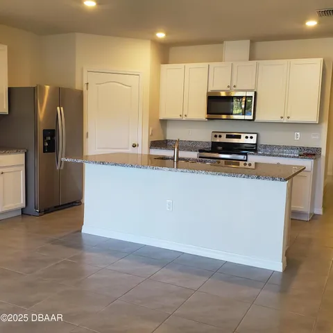 a kitchen with stainless steel appliances a refrigerator a stove top oven a sink and dishwasher