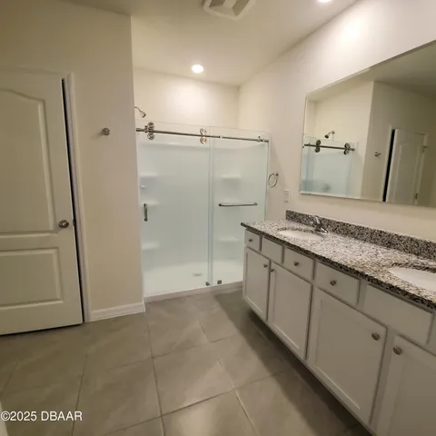 a spacious bathroom with a granite countertop sink mirror and shower
