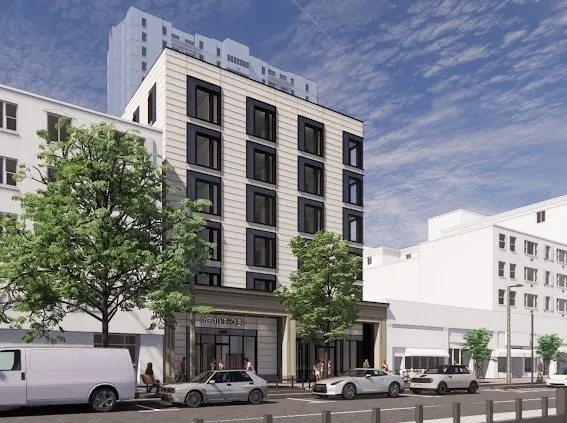 a front view of a building with lot of cars and trees