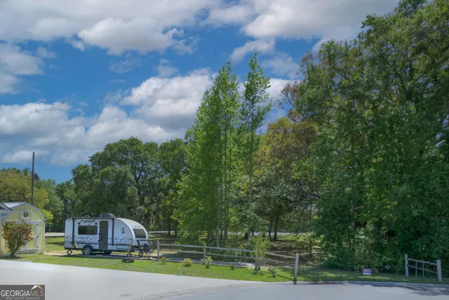 a front view of a house with a yard and large trees