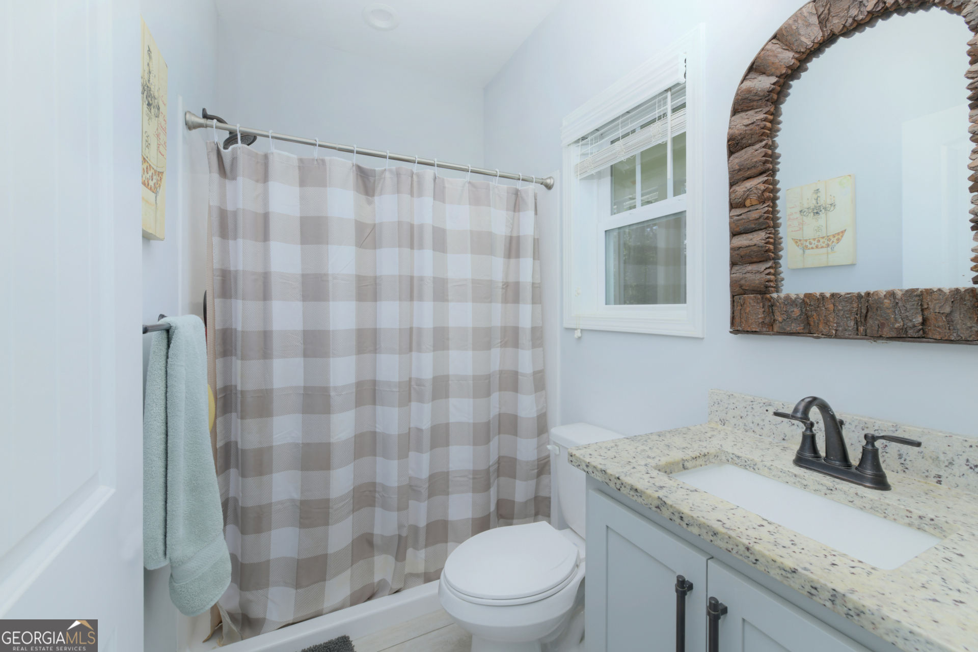 107 Elmo H Circle St. Marys, GA 31558 - Photo 24 of 31 a bathroom with a granite countertop sink a toilet a mirror and shower curtain