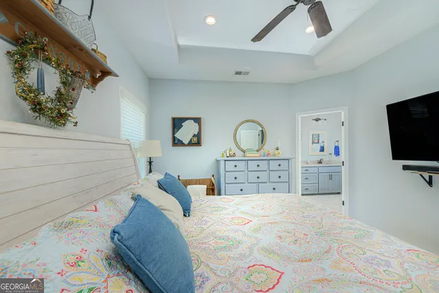 a bedroom with a bed and flat tv screen on the dresser