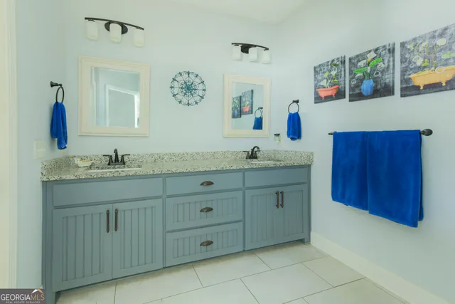 a bathroom with a granite countertop sink a mirror and vanity