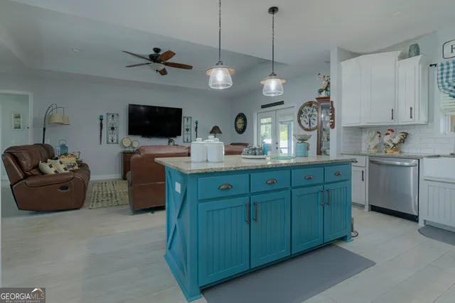 a large kitchen with cabinets a stove and a view of living room