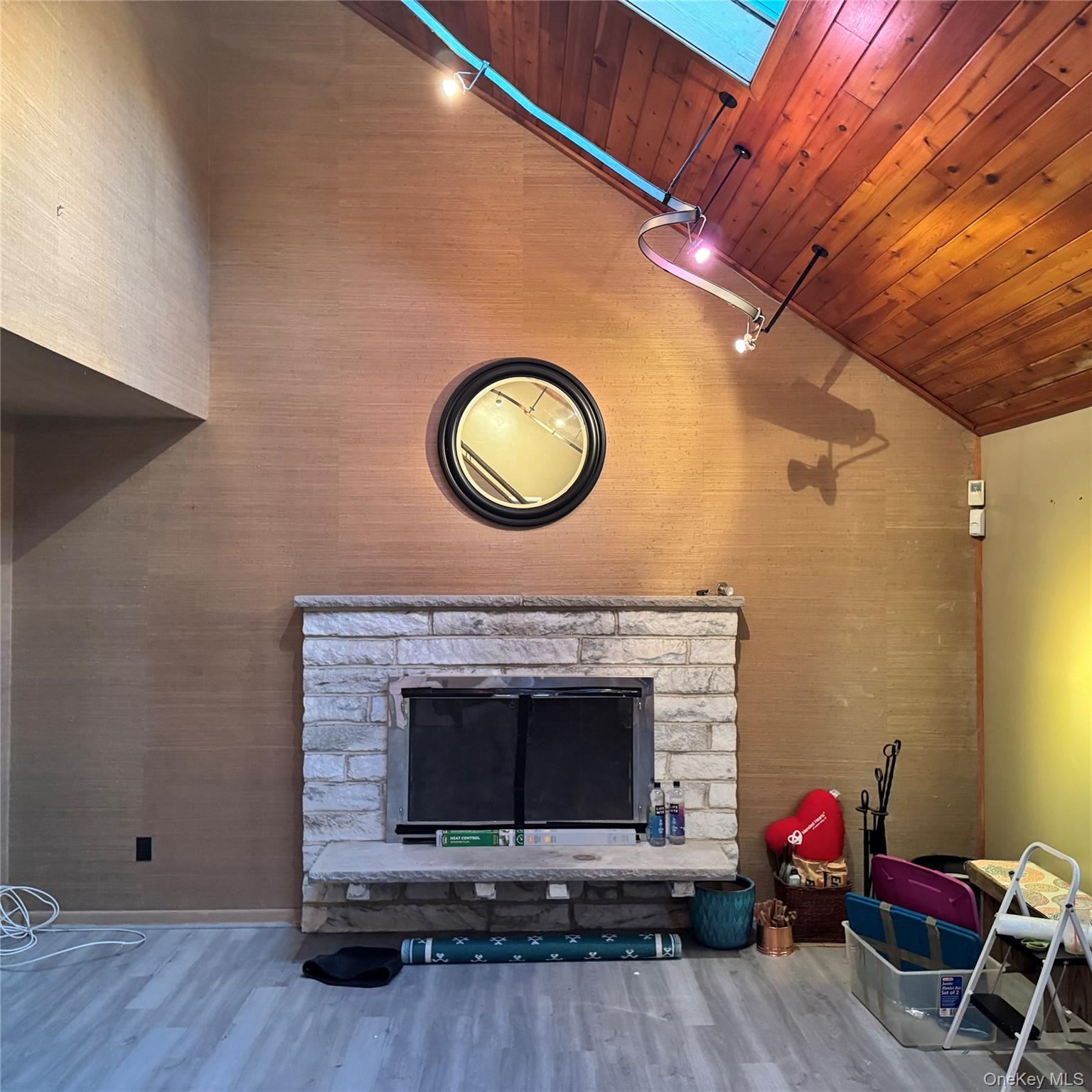67 Steele Road New Windsor, NY 12553 - Photo 5 of 34 Vaulted ceiling with wood-finish planks, stone-clad fireplace, and track lighting