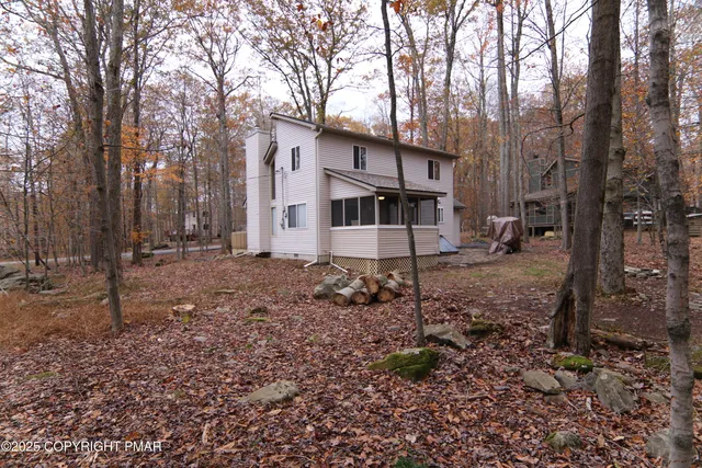 a view of a house with a yard and trees