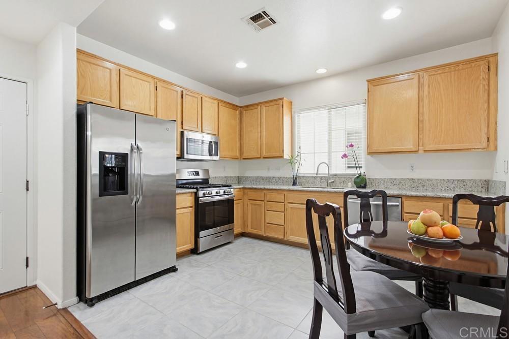 4002 Craven Road, Unit 4 Oceanside, CA 92057 - Photo 15 of 37 a kitchen with a refrigerator a sink a stove a dining table and chairs