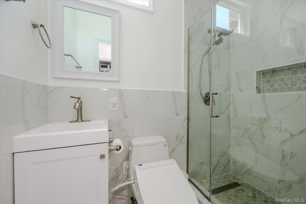 534 Allen Road Woodmere, NY 11598 - Photo 16 of 35 a bathroom with a sink a toilet and shower
