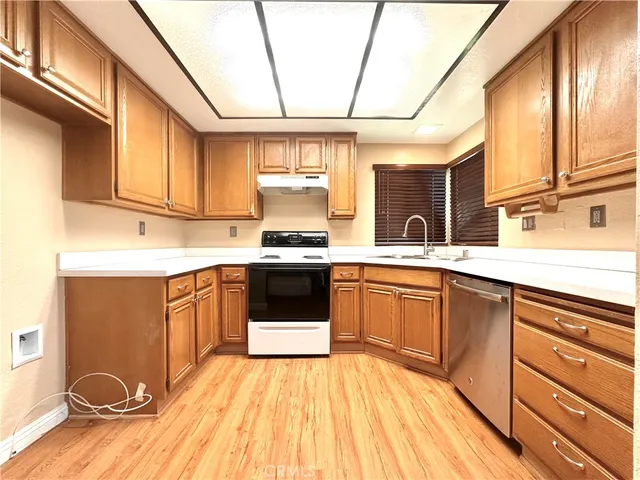 a kitchen with stainless steel appliances kitchen island granite countertop a sink cabinets and wooden floor
