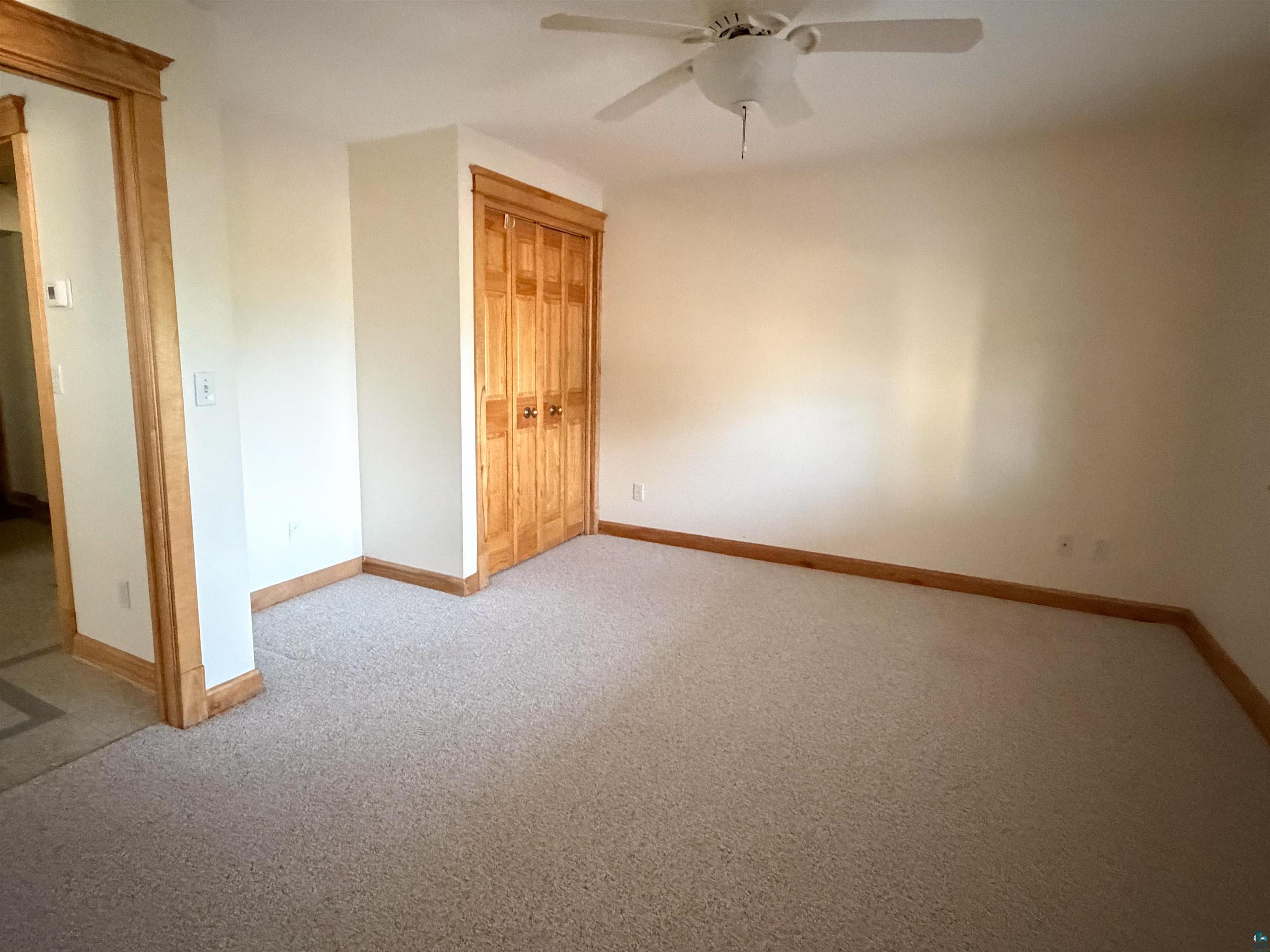 13 West 8th Street Duluth, MN 55806 - Photo 42 of 57 Room featuring light-toned carpeting, natural wood trim, and a ceiling fan with integrated lighting