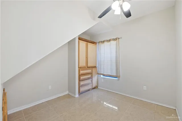 an empty room with closet and windows