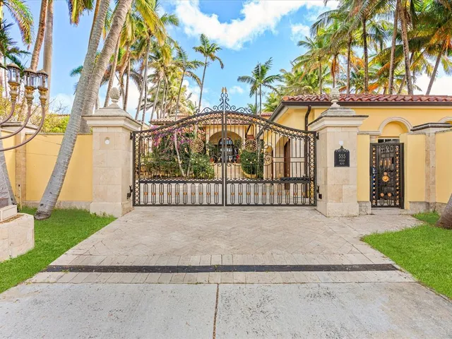 a view of a house with a yard and potted plants