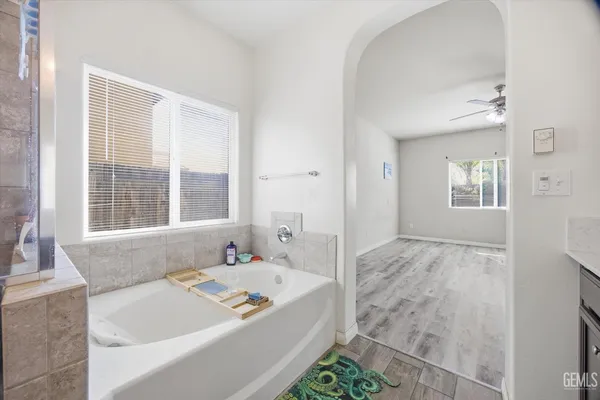 a bathroom with a tub a sink and a large mirror