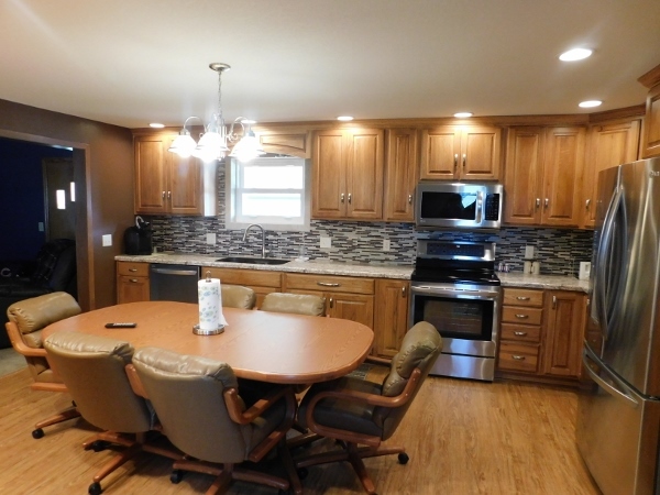 8388 South Brooklyn Road Rochelle, IL 61068 - Photo 9 of 32 a kitchen with stainless steel appliances kitchen island granite countertop a sink a stove a dining table and chairs