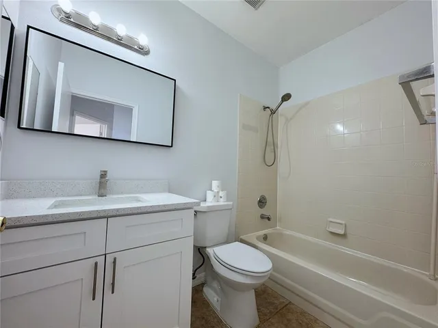 a bathroom with a toilet a sink a mirror and shower