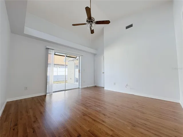 a view of room with hardwood floor and a ceiling fan