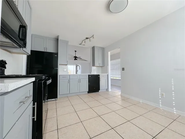 a kitchen with a refrigerator a stove top oven and cabinets
