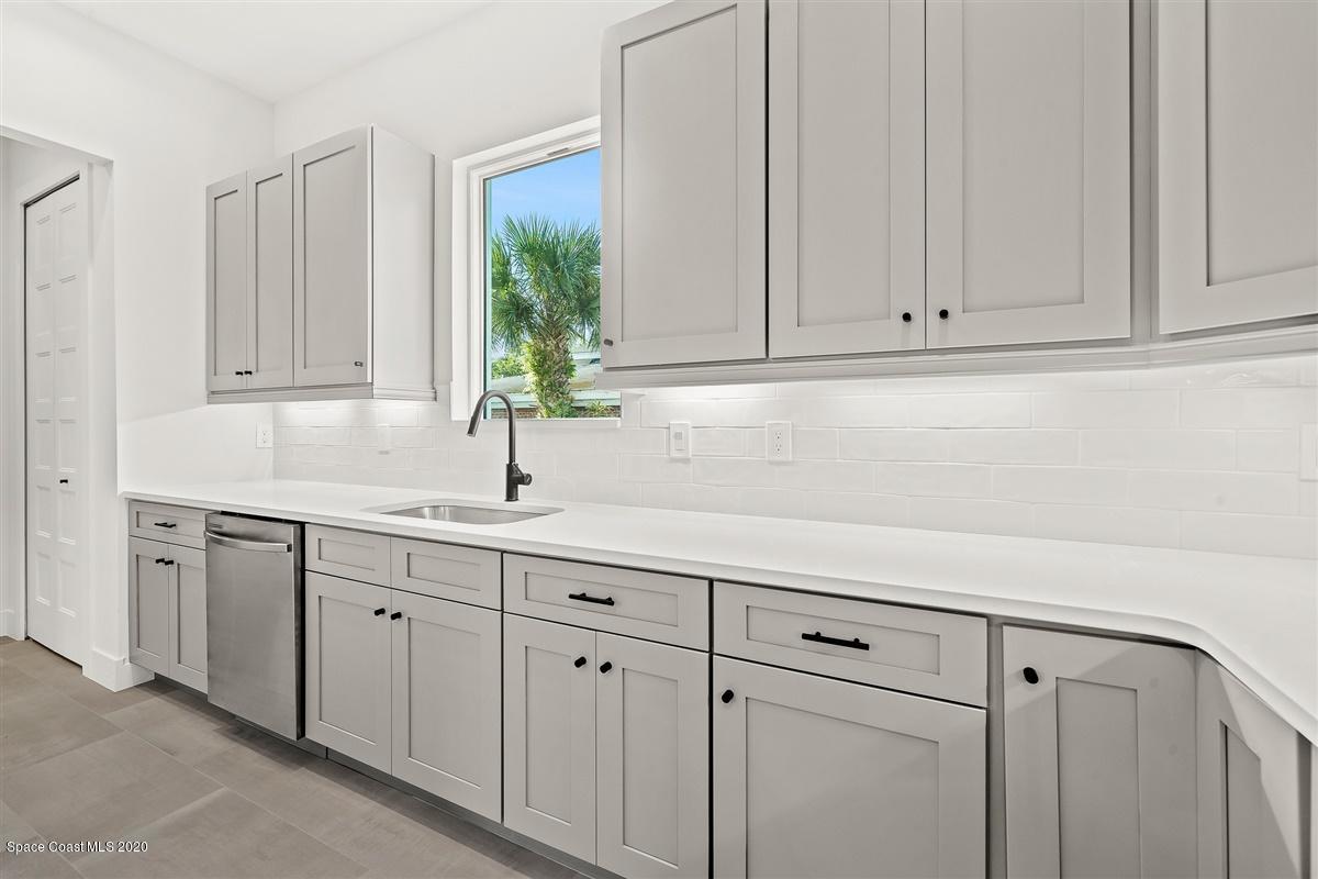 2158 Country Club Road Melbourne, FL 32901 - Photo 14 of 94 a kitchen with white cabinets and a sink