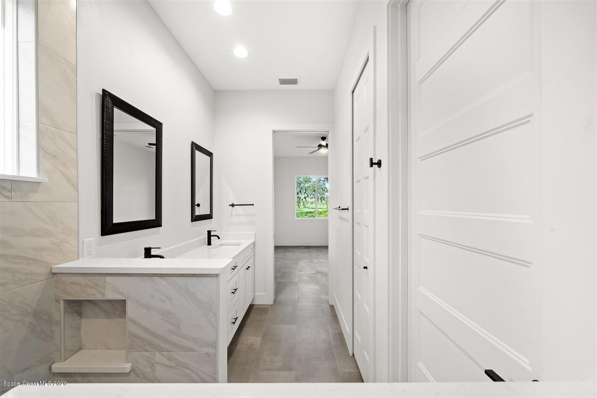 2158 Country Club Road Melbourne, FL 32901 - Photo 31 of 94 a bathroom with a sink a mirror and a bathtub