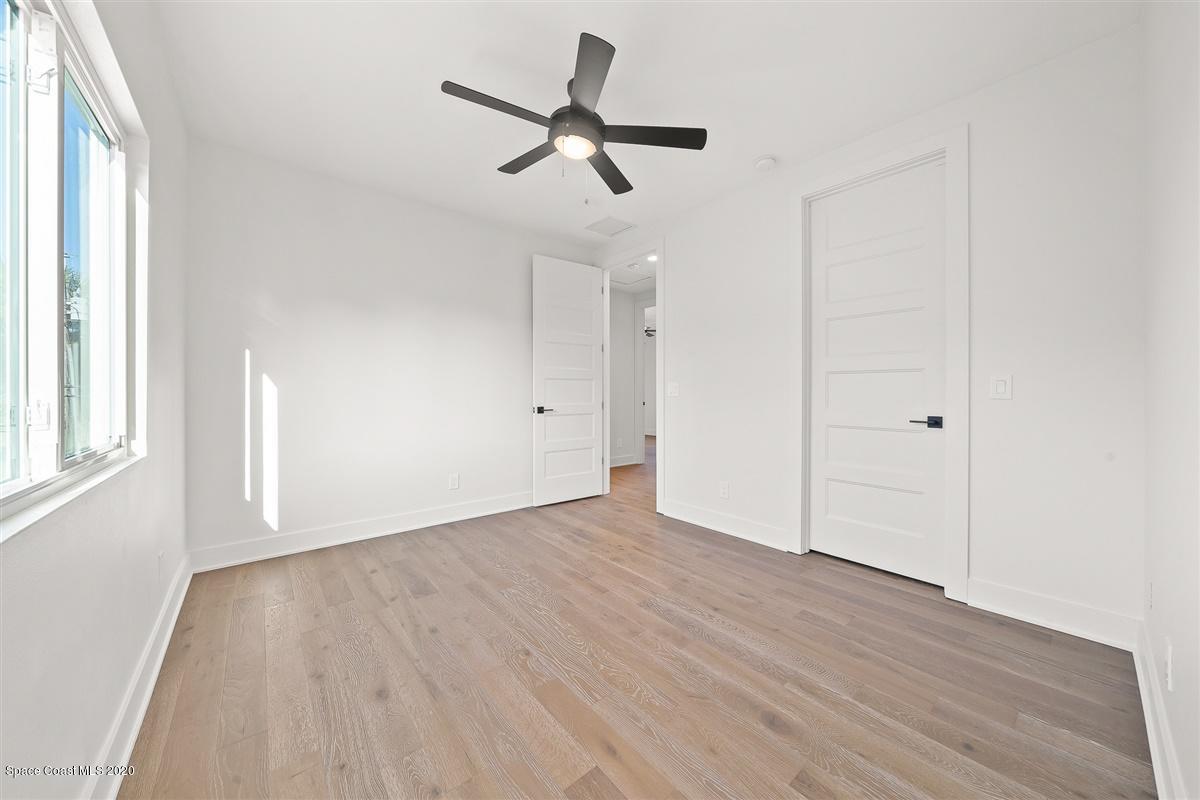 2158 Country Club Road Melbourne, FL 32901 - Photo 57 of 94 an empty room with wooden floor ceiling fan and windows
