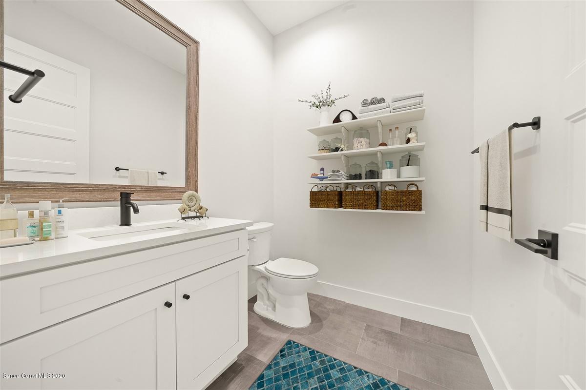 2158 Country Club Road Melbourne, FL 32901 - Photo 6 of 94 a bathroom with a sink a toilet and mirror