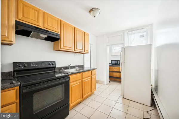 a kitchen with a stove top oven and cabinets