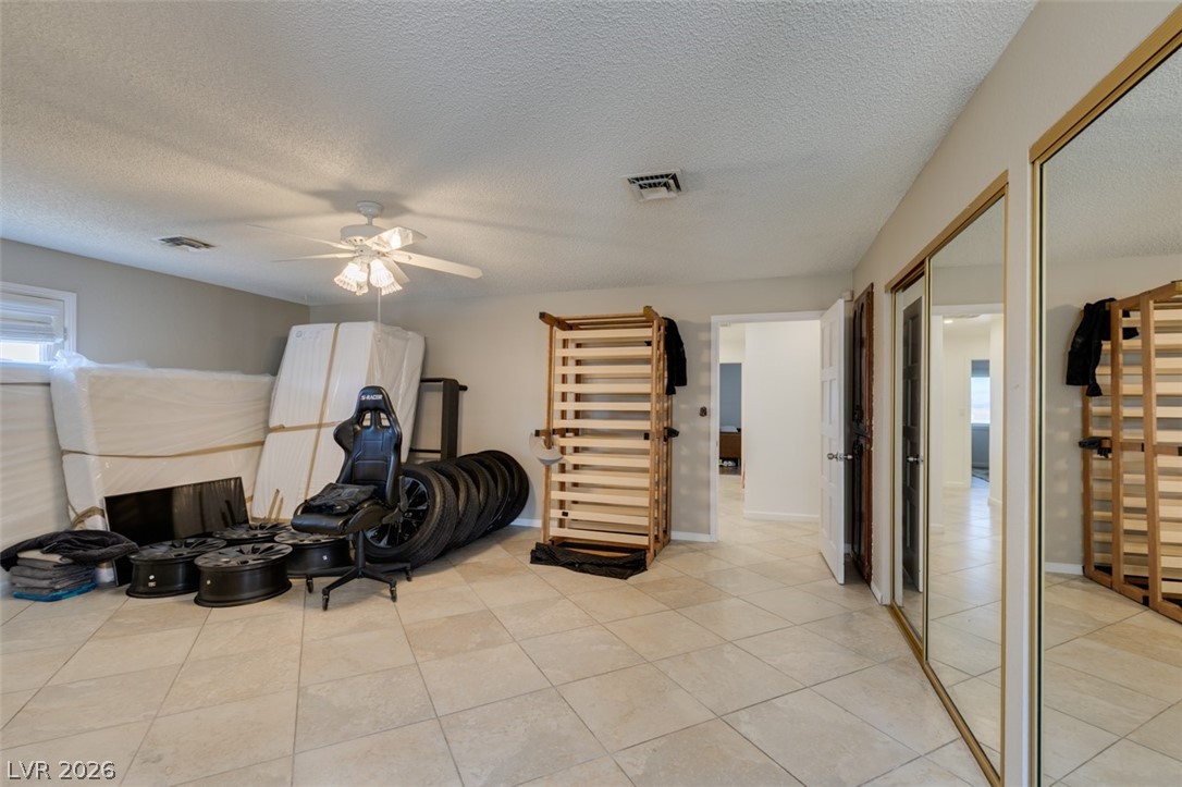 892 North Hollywood Boulevard Las Vegas, NV 89110 - Photo 36 of 81 This spacious bonus room features tiled flooring and mirrored closet doors, offering versatile living options.
