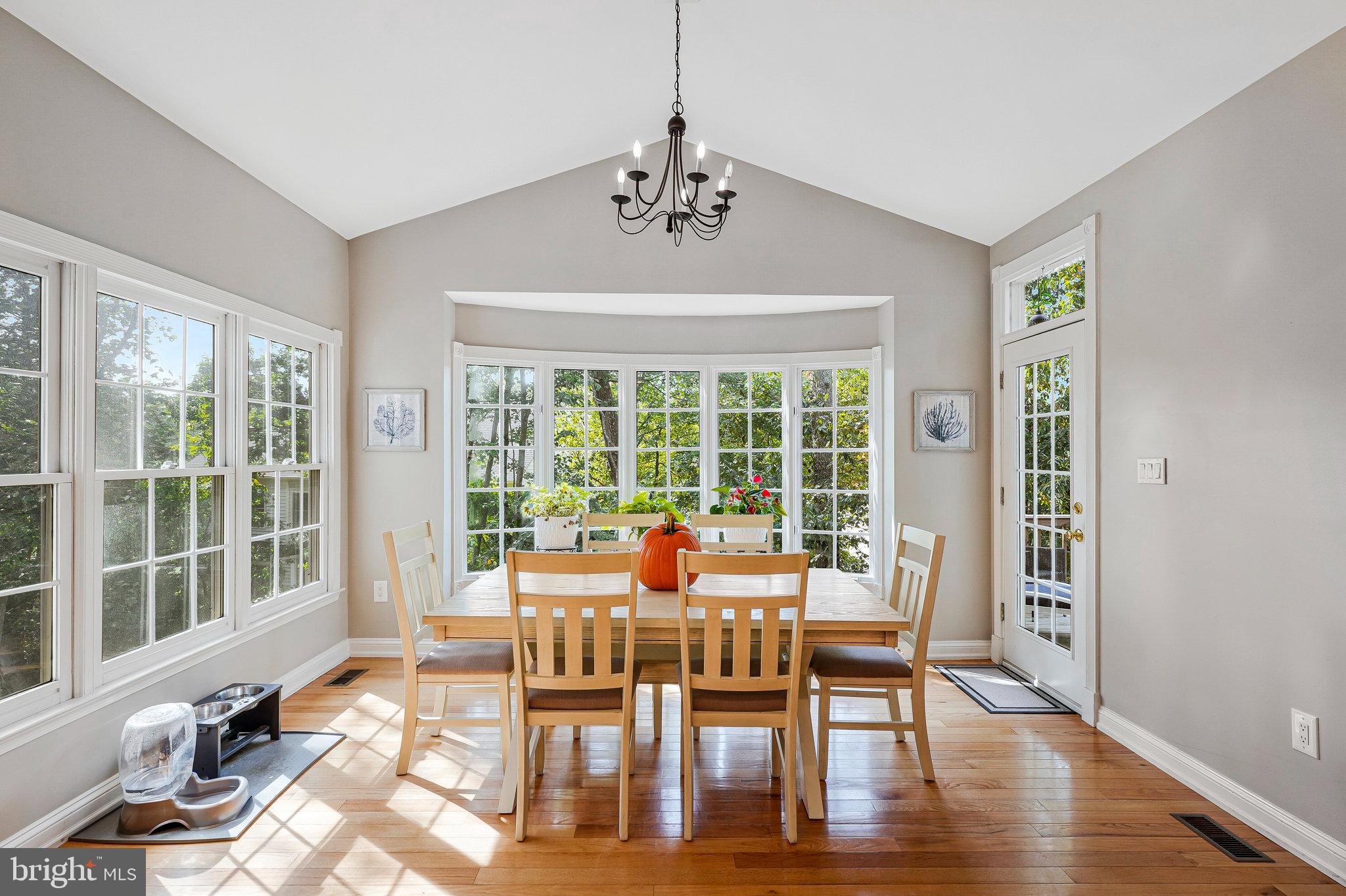 20627 Cutwater Place Sterling, VA 20165 - Photo 10 of 42 a dining room with wooden floor a chandelier a glass table and chairs