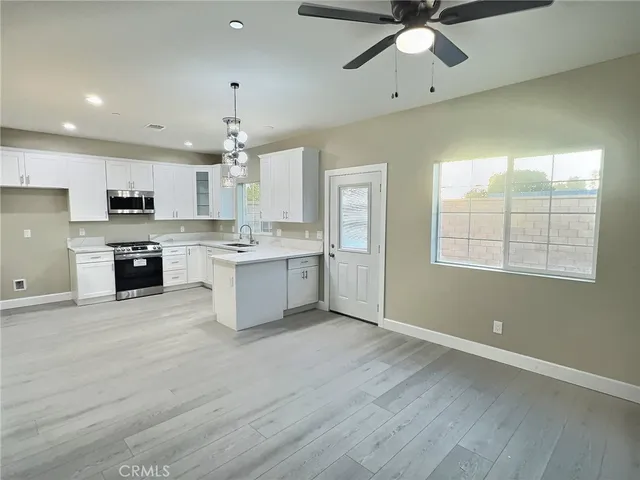 a large kitchen with cabinets wooden floor and stainless steel appliances