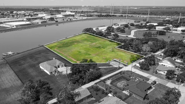 an aerial view of a house with a yard and lake view