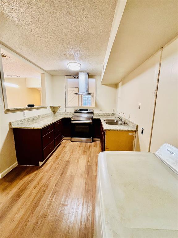 9696 Walnut Street, Unit 1305 Dallas, TX 75243 - Photo 12 of 25 a view of a kitchen with kitchen island stainless steel appliances a sink wooden floor and living room view