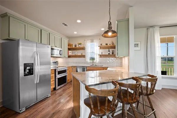 a kitchen with stainless steel appliances wooden cabinets and a stove top oven