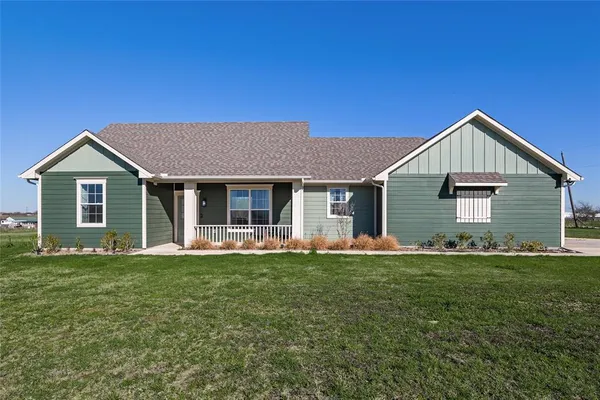 a front view of a house with a garden and yard