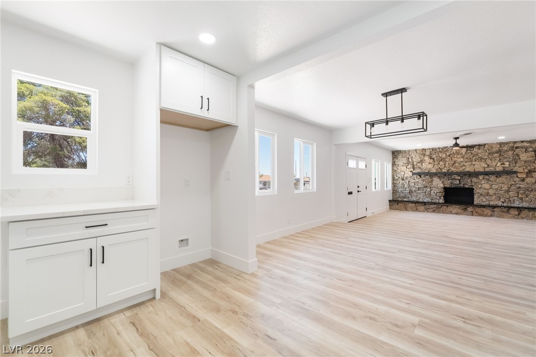 39 Lowery Street Henderson, NV 89015 - Photo 12 of 40 A striking stone fireplace anchors this bright living space with durable laminate flooring and abundant natural light.