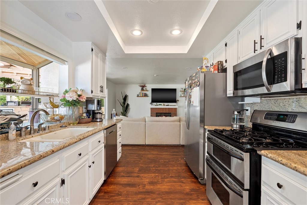 31256 Quail Valley Road Castaic, CA 91384 - Photo 5 of 16 a large white kitchen with stainless steel appliances granite countertop a stove a sink and a microwave