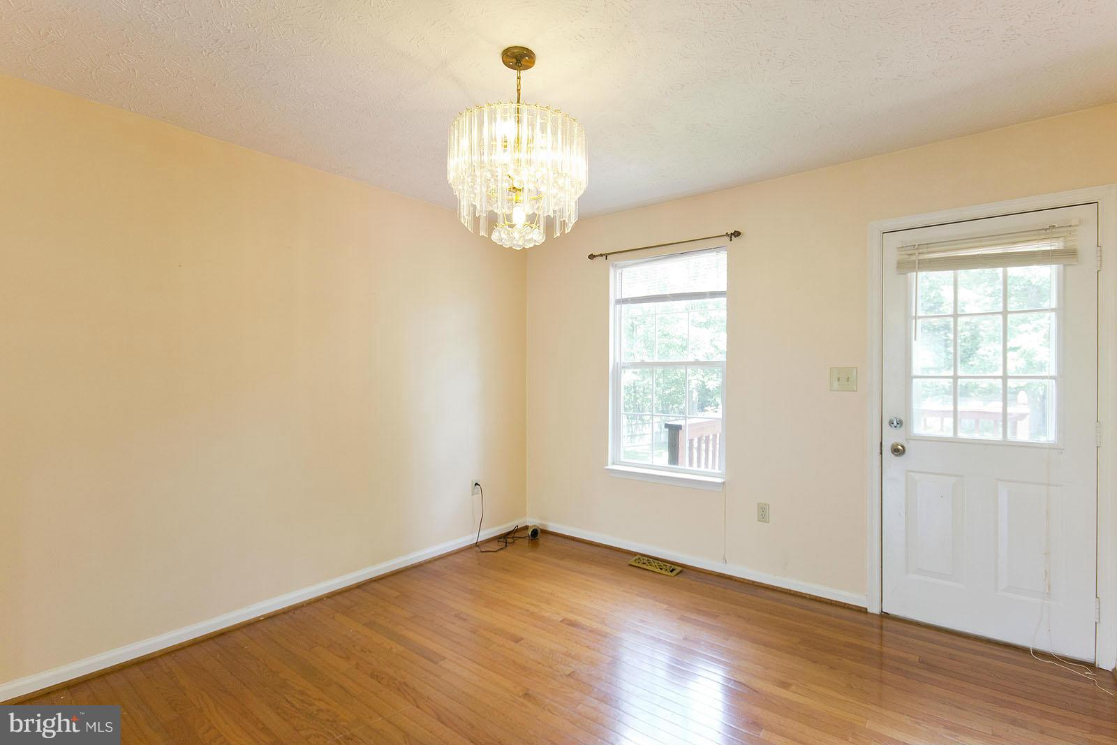 138 Charlton Road Winchester, VA 22602 - Photo 7 of 30 an empty room with wooden floor and windows