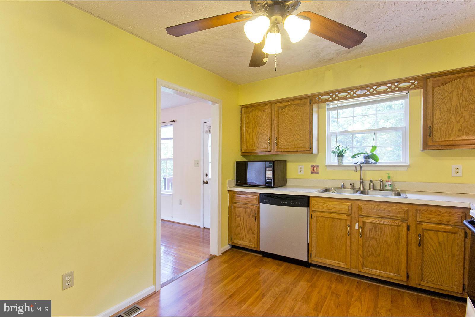 138 Charlton Road Winchester, VA 22602 - Photo 10 of 30 a kitchen with stainless steel appliances a sink cabinets and wooden floor
