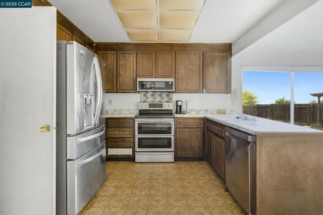 a kitchen with stainless steel appliances granite countertop a refrigerator and a stove
