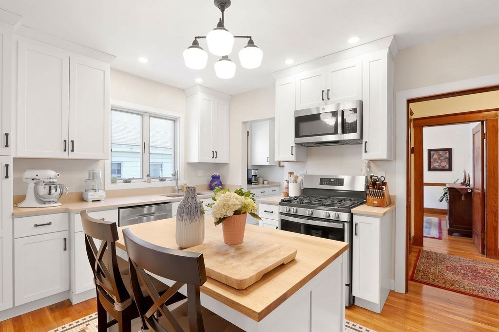 43-45 Owencroft Road, Unit 2 Boston, MA 02124 - Photo 12 of 36 a kitchen with stainless steel appliances granite countertop a stove top oven a sink a stove a dining table and chairs