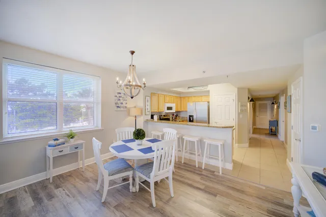 a dining room with furniture a chandelier and wooden floor