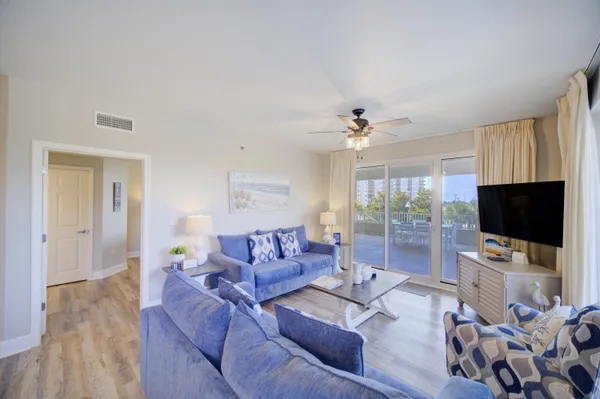 a living room with furniture a flat screen tv and a large window
